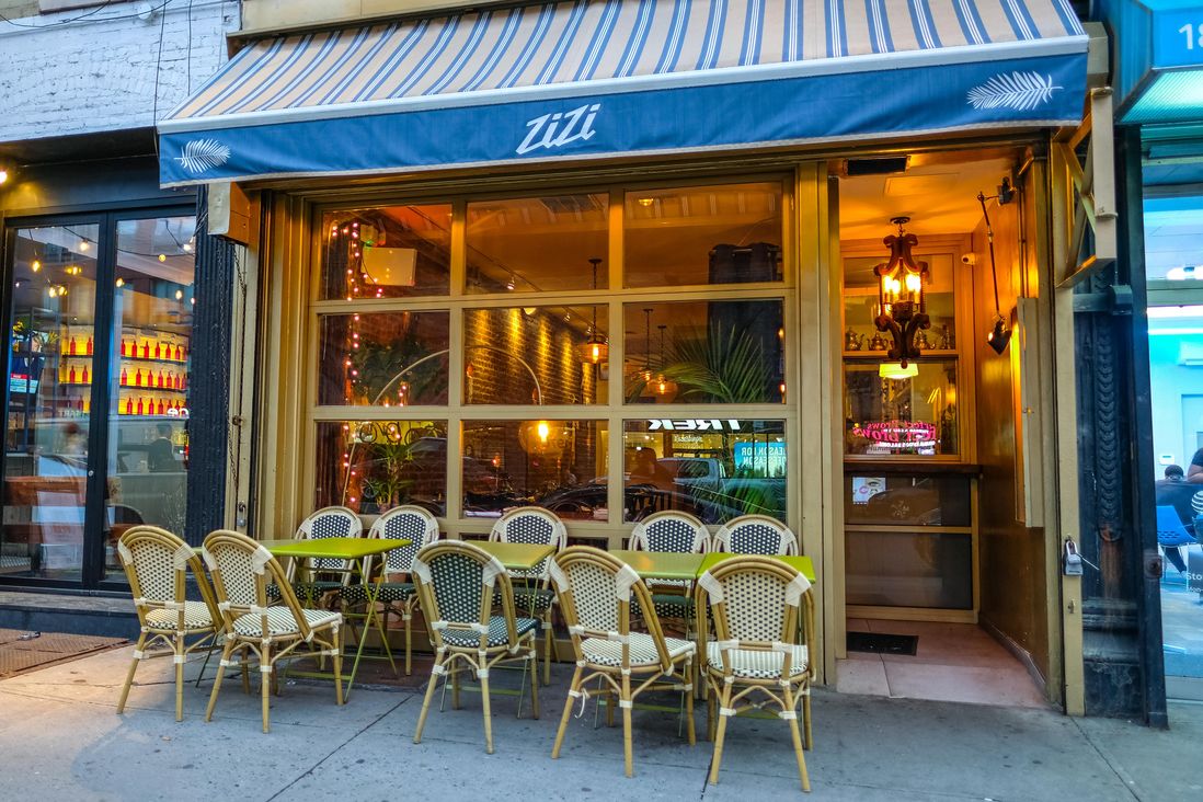 Exterior of Zizi Limona, showing awning and chairs on sidewalk